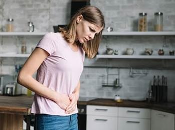 Woman holding stomach due to gut discomfort